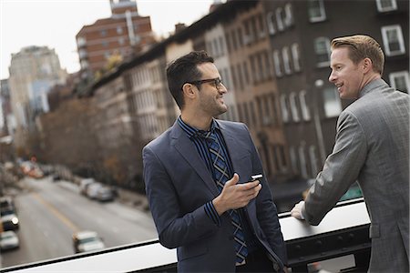 simsearch:6118-07440408,k - Two men standing talking on an elevated walkway above a city road. Stock Photo - Premium Royalty-Free, Code: 6118-07353625