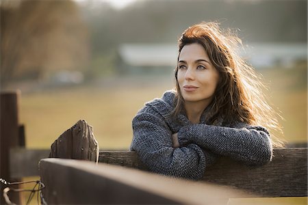 simsearch:6118-07354442,k - A woman leaning on a fence on an organic farm. Stock Photo - Premium Royalty-Free, Code: 6118-07353774