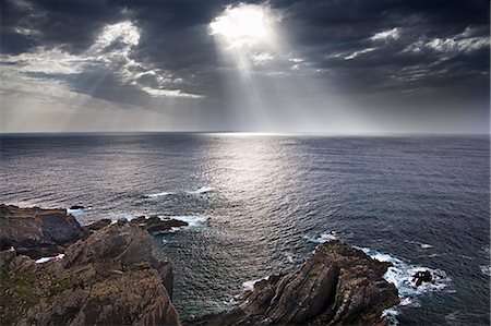 simsearch:6118-07353866,k - Cabo Sardao coastline in Portugal. Sun streaming through cloud on to the sea. Stock Photo - Premium Royalty-Free, Code: 6118-07353844