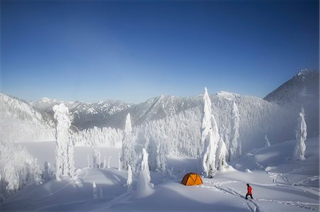 Man walks through deep powder to his campsite in the snow covered Cascade Mountains overlooking Snow Lake. Stock Photo - Premium Royalty-Free, Code: 6118-07353831