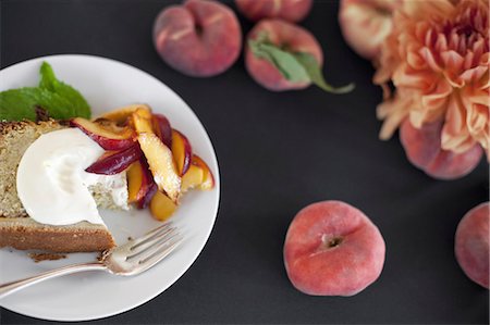 simsearch:6118-07354433,k - A table viewed from overhead. Organic fruit, peaches, and flowers. a plate with fresh fruit, cake and creme fraiche. A fork. Dessert. Stock Photo - Premium Royalty-Free, Code: 6118-07354084