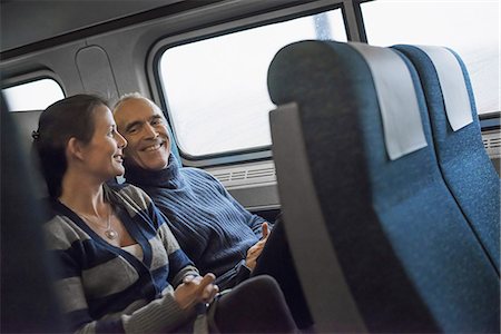 Two people sitting in a railway carriage, smiling. Taking a train journey. Photographie de stock - Premium Libres de Droits, Code: 6118-07354148