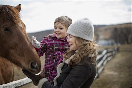 simsearch:6118-07354442,k - A woman and child patting a horse in a paddock on a farm. Stock Photo - Premium Royalty-Free, Code: 6118-07354198