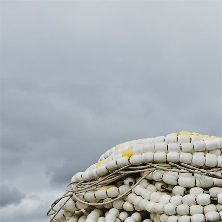 simsearch:6118-08910527,k - Pile of commercial fishing nets, with white floats, on the quayside at Fisherman's Terminal, Seattle. Photographie de stock - Premium Libres de Droits, Code: 6118-07354101