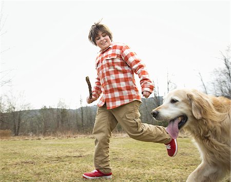 dog stick - A young boy outdoors on a winter day, holding a stick and running with a golden retriever dog. Stock Photo - Premium Royalty-Free, Code: 6118-07354110