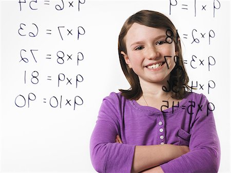 simsearch:632-03898264,k - A child looking at a series of multiplication tables written on a see through surface. Foto de stock - Sin royalties Premium, Código: 6118-07354255