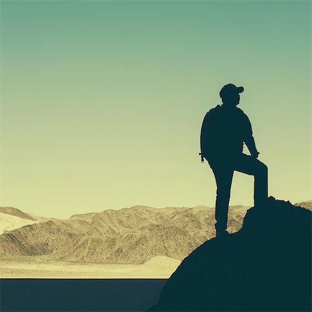 Silhouette of a hiker wearing a backpack, pausing to take in view of mountains and desert in Death Valley National Park. Stock Photo - Premium Royalty-Free, Code: 6118-07354266