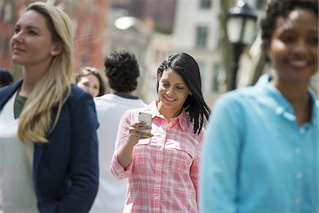 excitement outdoors - People outdoors in the city in spring time. New York City park. Three women, one checking her mobile phon. Stock Photo - Premium Royalty-Free, Code: 6118-07354350