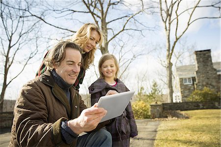 farmers family of three - An Organic Farm in Winter in Cold Spring, New York State.  A man holding a digital tablet in his hands. A woman and a child. Stock Photo - Premium Royalty-Free, Code: 6118-07354447