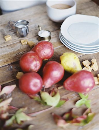 simsearch:6118-07354433,k - A domestic kitchen tabletop. A small group of fresh organic pears and a stack of white plates. Stock Photo - Premium Royalty-Free, Code: 6118-07354430