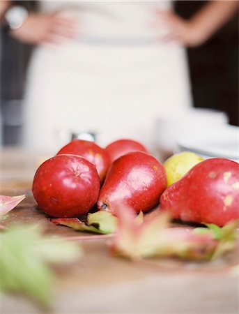 simsearch:6118-07354433,k - A domestic kitchen tabletop. A small group of fresh organic pears and a stack of white plates. Stock Photo - Premium Royalty-Free, Code: 6118-07354431