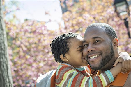 simsearch:6118-07354682,k - A New York city park in the spring. Sunshine and cherry blossom. A father and son in the park hugging. Stock Photo - Premium Royalty-Free, Code: 6118-07354672