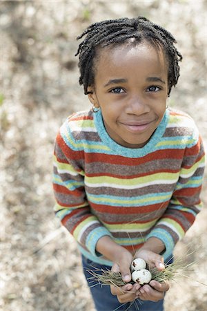 simsearch:6118-07353446,k - A New York city park in the spring. A small boy in a striped shirt, holding a nest with three birds eggs. Stock Photo - Premium Royalty-Free, Code: 6118-07354676