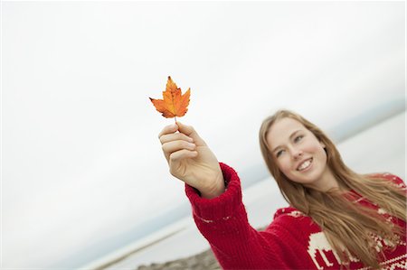 preteen girl - A day out at Ashokan lake. A young girl in a red winter knitted jumper holding up a maple leaf. Stock Photo - Premium Royalty-Free, Code: 6118-07440271