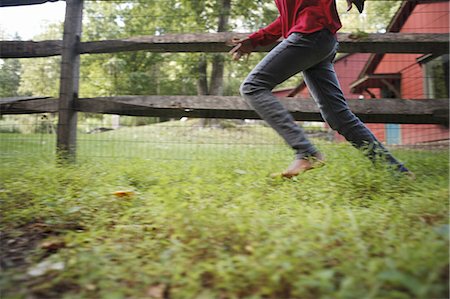 pov - A boy running around a paddock fence outdoors. Stock Photo - Premium Royalty-Free, Code: 6118-07440357