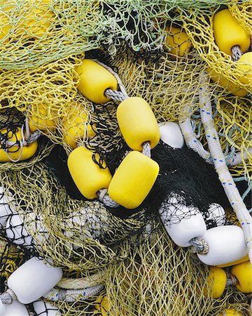 simsearch:6118-08910527,k - Pile of commercial fishing nets, with yellow and white floats, on the quayside at Fisherman's Terminal, Seattle. Stock Photo - Premium Royalty-Free, Code: 6118-07440777