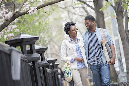 simsearch:6118-07354682,k - A couple walking in the park side by side carrying shopping bags. Stock Photo - Premium Royalty-Free, Code: 6118-07441040