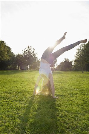 Teenage girl with long blond hair doing a headstand. Stock Photo - Premium Royalty-Free, Code: 6118-07521759