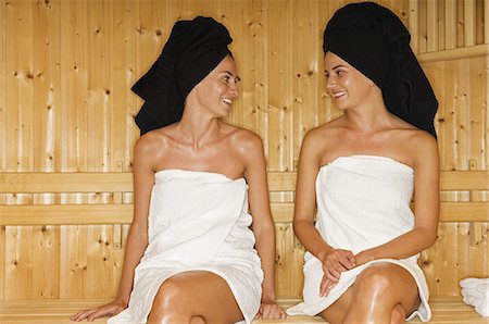 A wooden panelled sauna. Two women seated talking. Stock Photo - Premium Royalty-Free, Code: 6118-07521847
