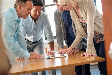 share tablet office - A woman and four men gathered around a digital tablet on a tabletop, in an office. Stock Photo - Premium Royalty-Free, Code: 6118-07769514
