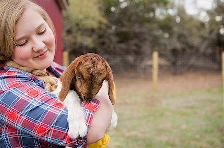 simsearch:6118-07731886,k - A girl cuddling a baby goat. Stock Photo - Premium Royalty-Free, Code: 6118-07731890