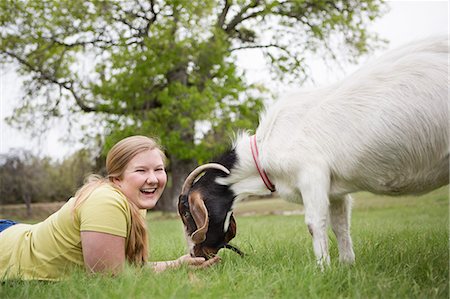simsearch:6118-07731886,k - A girl lying on grass head to head with a goat. Stock Photo - Premium Royalty-Free, Code: 6118-07731895