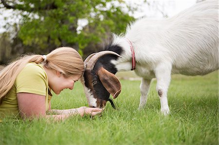 simsearch:6118-07731886,k - A girl lying on grass head to head with a goat. Stock Photo - Premium Royalty-Free, Code: 6118-07731896