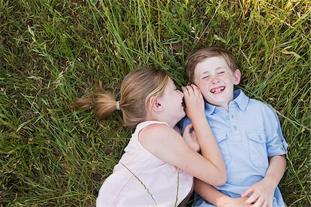 Two children, brother and sister lying side by side on the grass Stock Photo - Premium Royalty-Free, Code: 6118-07731956