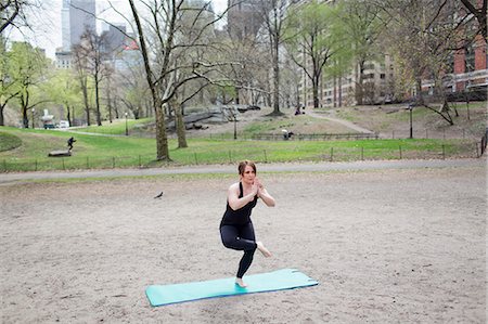 simsearch:6118-07731916,k - A young woman in Central Park, in a black leotard and leggings, doing yoga. Photographie de stock - Premium Libres de Droits, Code: 6118-07731912