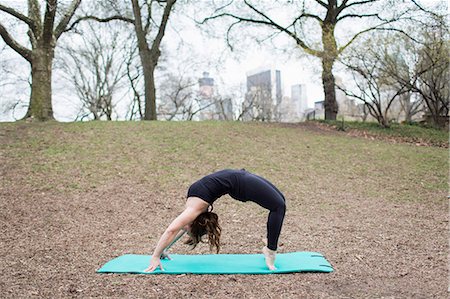 simsearch:6118-07731916,k - A young woman in Central Park, in a black leotard and leggings, doing yoga. Photographie de stock - Premium Libres de Droits, Code: 6118-07731918