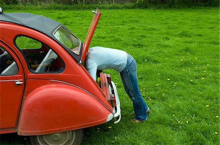 A  person leaning in to the boot at the rear of the car. Stock Photo - Premium Royalty-Free, Code: 6118-07731928