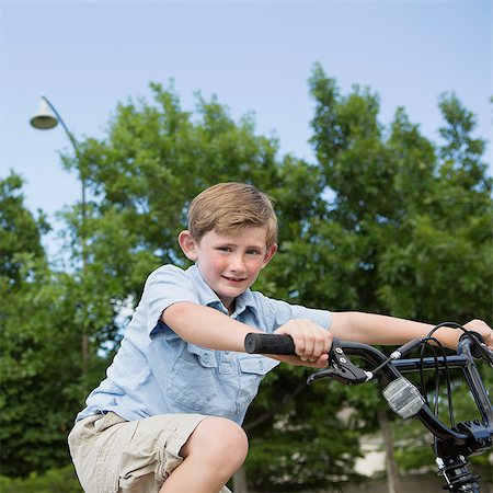 freckles - A young boy riding a bicycle. Stock Photo - Premium Royalty-Free, Code: 6118-07732005