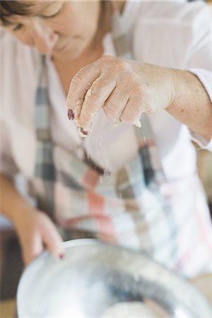 simsearch:6118-07808971,k - A woman measuring and sifting white flour, making a crumble topping. Home baking. Stock Photo - Premium Royalty-Free, Code: 6118-07808926