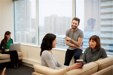 relaxation in the office - Three people by a window in an office, two women and a man. Stock Photo - Premium Royalty-Free, Code: 6118-08066748