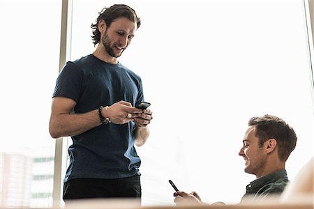 simsearch:6118-08243810,k - Two men in an office, checking their smart phones. Stock Photo - Premium Royalty-Free, Code: 6118-08066728