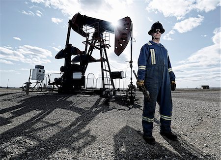 plain - A man in overalls and hard hat at a pump jack in open ground at an oil extraction site. Stock Photo - Premium Royalty-Free, Code: 6118-08081886