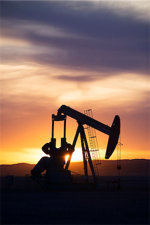 pump jack - A pumpjack at an oil drilling site at sunset. Stock Photo - Premium Royalty-Free, Code: 6118-08088548