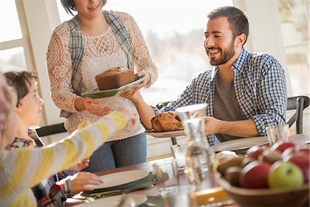 A group of people, adults and children, seated around a table for a meal. Stock Photo - Premium Royalty-Free, Code: 6118-08001575