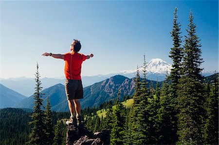 Male hiker standing with his arms outstretched on a mountain top, looking over the landscape. Stock Photo - Premium Royalty-Free, Code: 6118-08001524