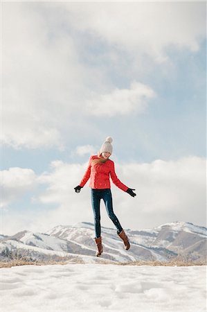 simsearch:6118-08140197,k - A young girl with long legs and red jacket, leaping in the air above the snow Stock Photo - Premium Royalty-Free, Code: 6118-08023790