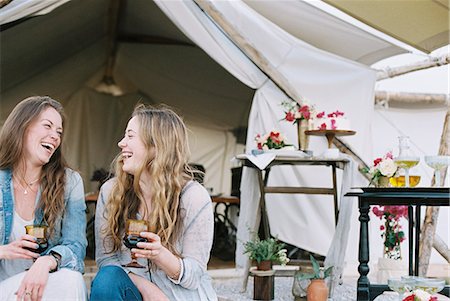 simsearch:6118-08140197,k - Two smiling women sitting outside a tent in a desert, enjoying a glass of wine. Stock Photo - Premium Royalty-Free, Code: 6118-08140152