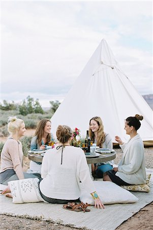 simsearch:6118-08140197,k - Group of women enjoying an outdoor meal by a teepee in the desert. Stock Photo - Premium Royalty-Free, Code: 6118-08140155