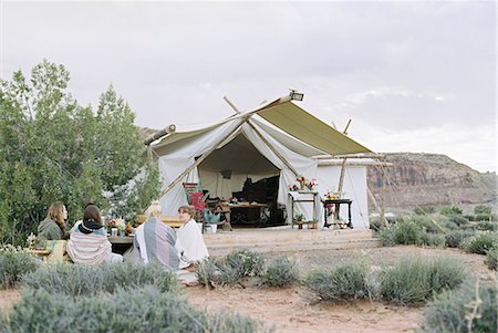 simsearch:6118-08140197,k - Group of women friends enjoying an outdoor meal in a desert by a large tent. Stock Photo - Premium Royalty-Free, Code: 6118-08140158