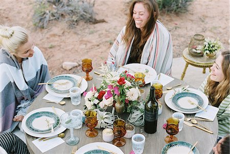 A small group of women enjoying an outdoor meal in a desert. Stock Photo - Premium Royalty-Free, Code: 6118-08140160