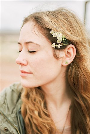 simsearch:6118-08140197,k - Head and shoulders portrait of a woman with a flower in her hair. Stock Photo - Premium Royalty-Free, Code: 6118-08140164