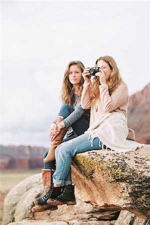 simsearch:6118-08140197,k - Two women sitting side by side on a rock in a desert, one holding a camera. Stock Photo - Premium Royalty-Free, Code: 6118-08140202