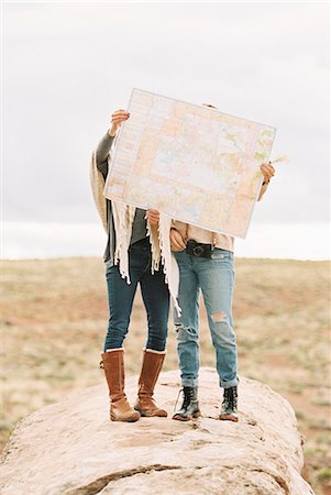 simsearch:6118-08140197,k - Two women standing in a desert, holding up a large map in front of their faces. Stock Photo - Premium Royalty-Free, Code: 6118-08140211