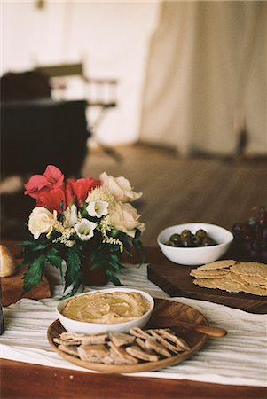 simsearch:6118-07808971,k - Bowls with hummus and olives and a vase of flowers on a table. Stock Photo - Premium Royalty-Free, Code: 6118-08140215