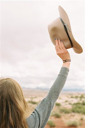 simsearch:6118-08140197,k - Rear view of a woman standing in the desert, holding a hat, her arms raised up in the air. Stock Photo - Premium Royalty-Free, Code: 6118-08140230