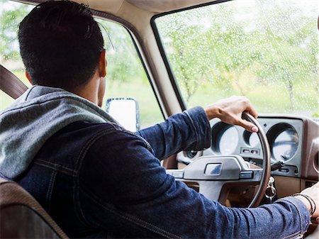 simsearch:6118-08129648,k - Young man in a car behind the steering wheel, driving. Foto de stock - Sin royalties Premium, Código: 6118-08129666